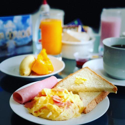 a plate of breakfast food with a hot dog and toast at Hotel Selva Dorada in Iquitos