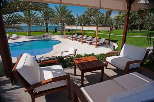 a patio with lounge chairs and a swimming pool at La Hacienda Bahia Paracas in Paracas