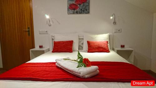 un lit avec des draps rouges et blancs et des oreillers rouges dans l'établissement Villa Henriques, à Funchal