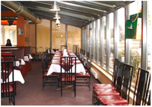 una fila de mesas y sillas en un restaurante en Motel Du Parc Masson en Gatineau