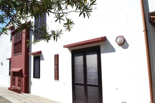 a white house with black doors and windows at Villa Aurora in Vico Equense