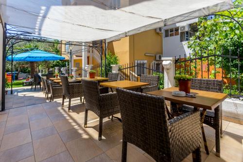 an outdoor patio with tables and chairs and an umbrella at Villa Jadranka Sutomore in Sutomore