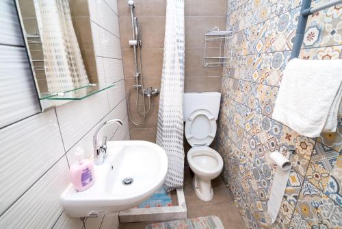 ein Badezimmer mit einem weißen Waschbecken und einem WC in der Unterkunft Elena Apartments in Kanali