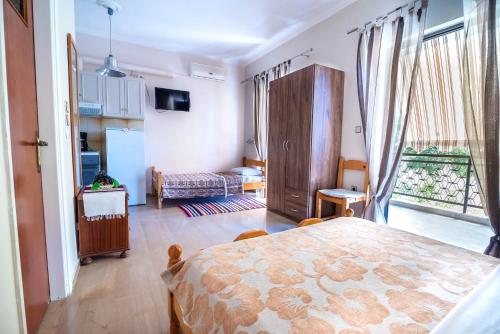 Una sala de estar con una mesa y un dormitorio. en Elena Apartments, en Kanali