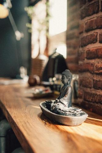 a small statue sitting on top of a wooden table at 36 Phô Cô Hotel & Suites in Weimar