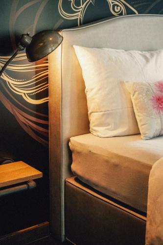 a bedroom with a bed with a lamp and a pillow at 36 Phô Cô Hotel & Suites in Weimar