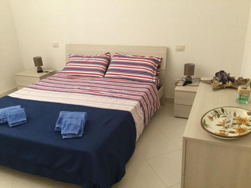 um quarto com uma cama com lençóis azuis e duas mesas de cabeceira em Residenza la Gioiosa. em Scarlino