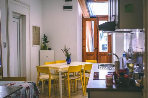 uma cozinha com uma mesa e cadeiras amarelas num quarto em Anchi Guesthouse em Dubrovnik