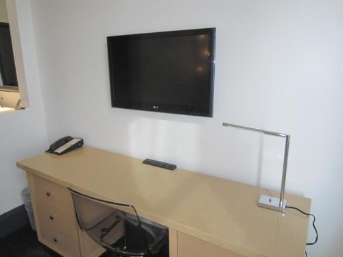 a room with a desk with a tv on the wall at La Pensione Hotel in San Diego