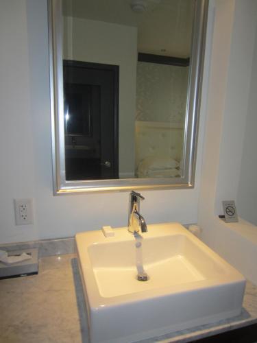 a white sink in a bathroom with a mirror at La Pensione Hotel in San Diego