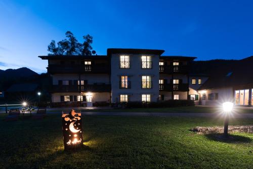a large building with lights in front of it at night at Ferienwohnungen Hotel Garni Dörflerwirt in Aflenz Kurort