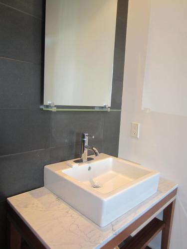 a bathroom with a white sink and a mirror at La Pensione Hotel in San Diego