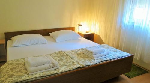 sypialnia z łóżkiem z ręcznikami w obiekcie Apartments Rukavina w mieście Umag