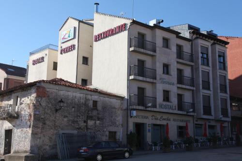 un edificio con un coche aparcado delante de él en Hostal Torres, en San Leonardo de Yagüe