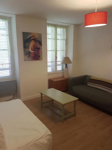 a living room with a couch and a coffee table at La Laverie in Saint-Jean-dʼAngély