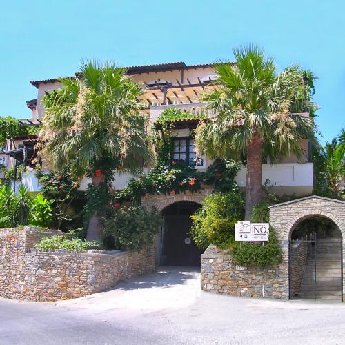 a building with palm trees in front of it at Ino Hotel & Suites in Samos