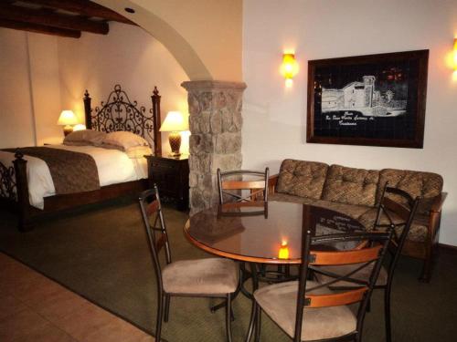 a bedroom with a bed and a table and chairs at Hotel Quinta Mision in Creel