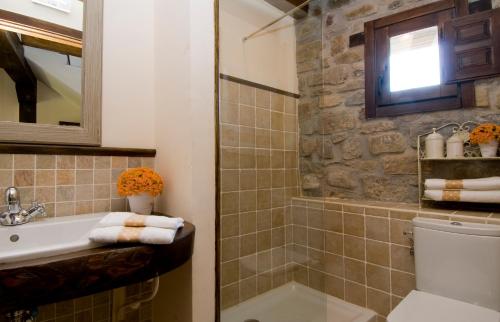 een badkamer met een wastafel, een toilet en een bad bij Casa Tio Conejo in San Román de Cameros