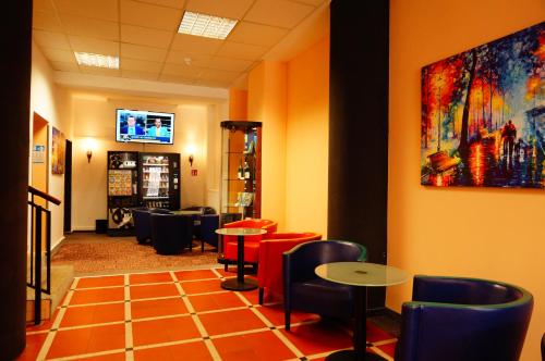 a restaurant with tables and chairs and a painting on the wall at sweet dream hostel & pension - Self Check-In in Güstrow