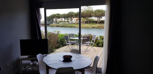 Cette chambre dispose d'une table et offre une vue sur la rivière. dans l'établissement Marina village, à Saint Cyprien Plage