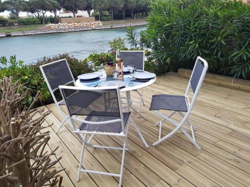 une table et deux chaises assises sur une terrasse dans l'établissement Marina village, à Saint Cyprien Plage