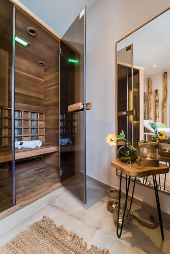 a glass shower in a room with a table at Sunshine Boutique Hotel by Estia in Malia