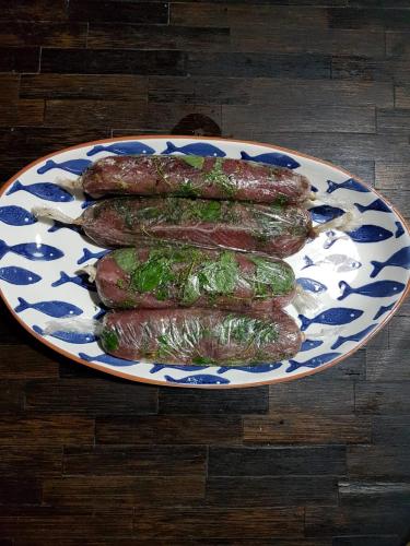 a plate of sausages on a wooden table at Ecolodge el Arca Bahia Solano in Bahía Solano
