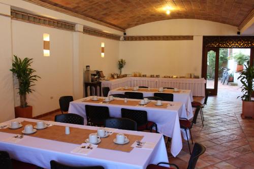 萊瓦鎮的住宿－Hotel Boutique La Española，用餐室配有桌椅和白色的桌布
