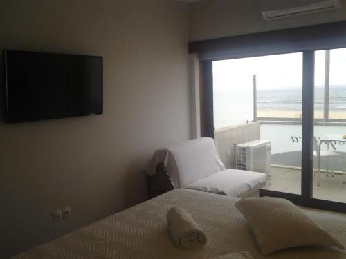 a bedroom with a bed and a flat screen tv at Guest House A&z in Espinho
