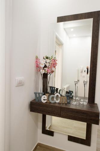 a mirror on a wall with a shelf with flowers at Central Park Lux in Arandjelovac
