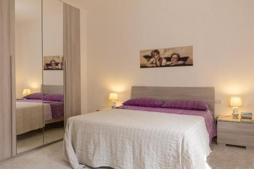 a bedroom with a large bed and a mirror at CASA VACANZA VALLEDORIA 2 in Valledoria
