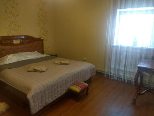 a bedroom with a bed with a table and a window at Hotel Andreevsky in Vinnytsya