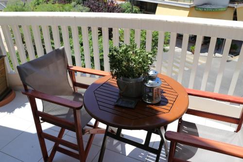 a table and two chairs on a balcony with a potted plant at Esperia Boutique Hotel in Agrinion