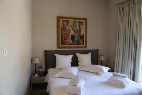 a bedroom with a bed with white sheets and pillows at Esperia Boutique Hotel in Agrinion