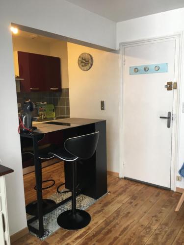 une cuisine avec un bureau noir et une porte dans l'établissement studio TIMGIO, à Wimereux