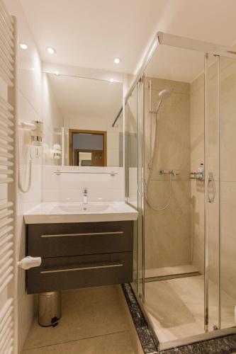 a bathroom with a sink and a shower at Löwen Hotel & Restaurant in Wendlingen am Neckar