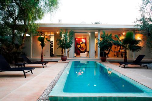 a swimming pool in front of a house at Dar Sabra in Marrakech