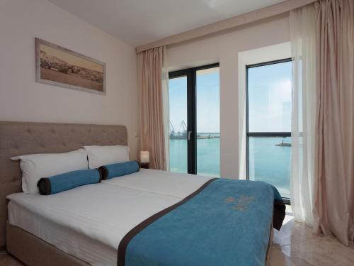 a bedroom with a bed with a view of the ocean at Antik Apartments in Balchik