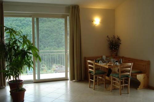 ein Esszimmer mit einem Tisch und einem großen Fenster in der Unterkunft Agape in Caprino Veronese