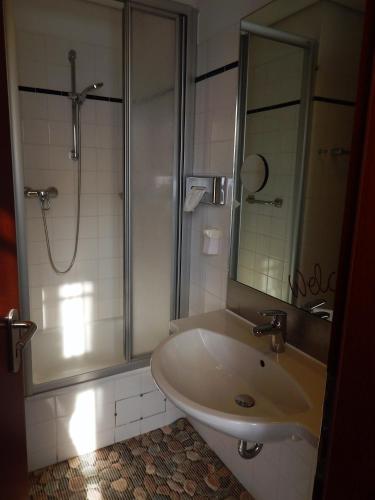 a bathroom with a sink and a shower at sweet dream hostel & pension - Self Check-In in Güstrow