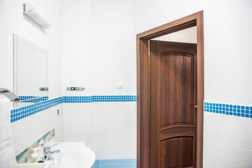 a bathroom with a sink and a wooden door at Apartamenty Niegocin in Wilkasy