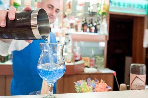 a woman pouring water into a wine glass at BSA Gradina Hotel & Aquapark - All Inclusive in Golden Sands