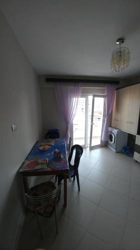 a kitchen with a table and chairs and a microwave at Mona`s Hostel in Sarandë