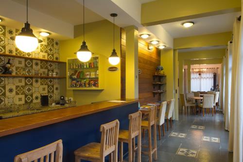 a restaurant with a bar with wooden tables and chairs at Pousada Il Villaggio in Santo Antônio do Pinhal