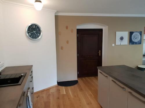 a kitchen with a clock on the wall and a door at The Gusto apartmán in Chomutov