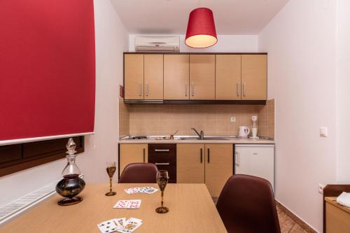 cocina con mesa con sillas y lámpara roja en Emotions, en Skala Potamias