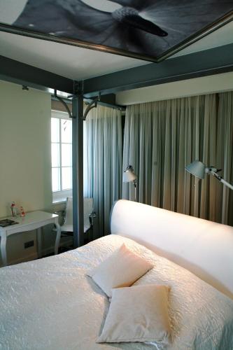 a hotel room with a bed and a desk and a bed sidx sidx at Boutique Hotel MaMa in Jūrmala