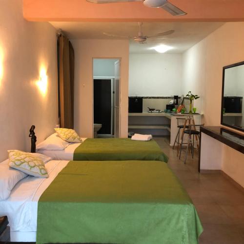 a hotel room with two beds and a kitchen at Condo Mar Arena in Playa del Carmen