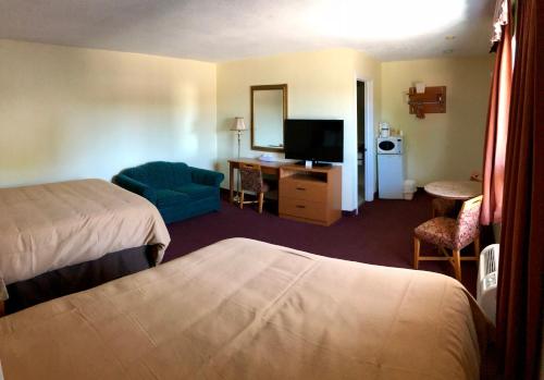 a hotel room with two beds and a television at Huntsville Inn in Huntsville