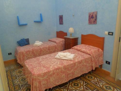 two beds in a room with blue walls at Casa Millenovecento in Brindisi